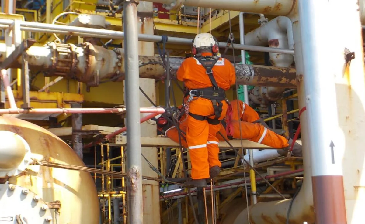 Aplicador da TecnoFink em alpinismo industrial sobre tubulação de processo em plataforma