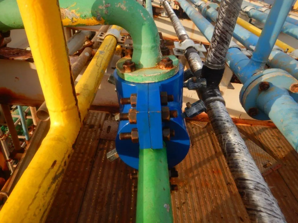 Dispositivo TVVA azul instalado em tubulação verde em plataforma offshore