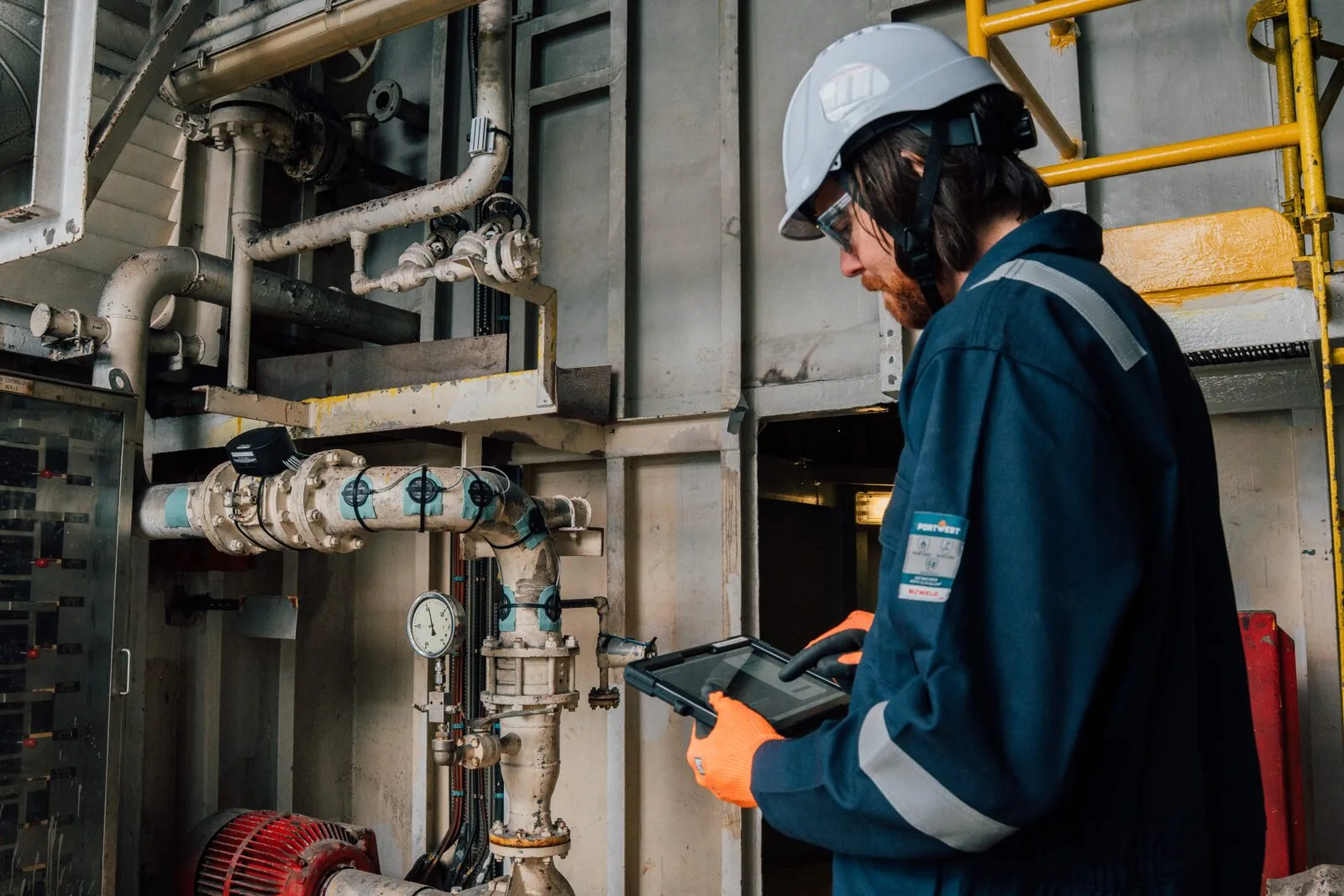 Técnico analisando dados do iDART em tablet durante inspeção em planta industrial