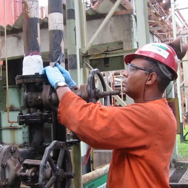 Técnico aplicando bandagem estrutural em tubulação industrial