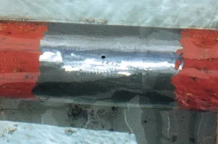 Tubo furado submerso em água com vazamento ativo